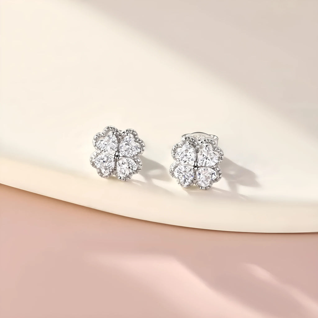 A pair of 925 silver four-leaf clover earrings with zircon stones in a heart-shaped setting.
