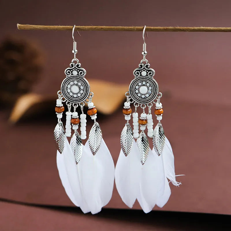 Round drop feather earrings in alloy with electroplated finish showing leaf shape and pattern details