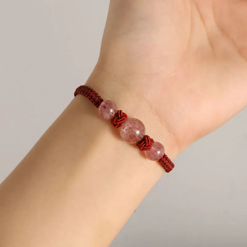 Woven red rope bracelet with strawberry quartz sphere beads and alloy detailing