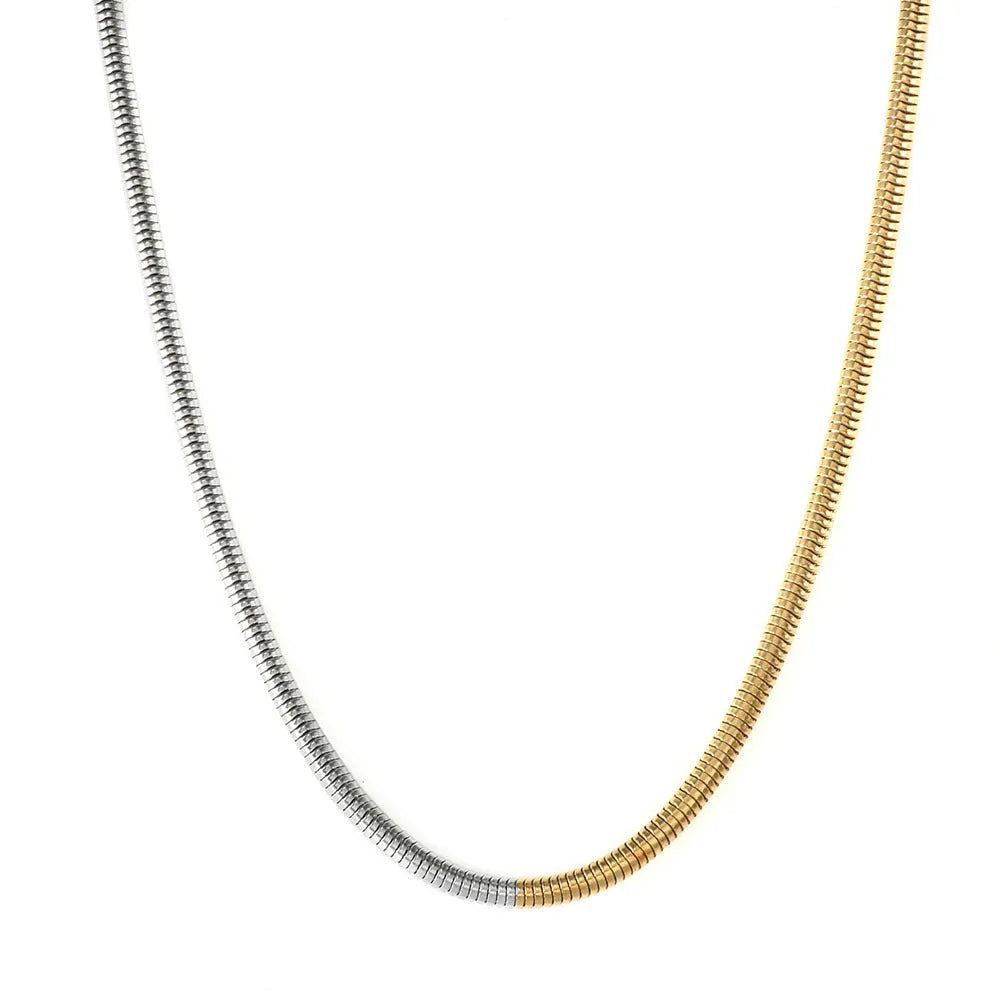 Gold-coloured snake bone chain necklace with geometric links on a white background.
