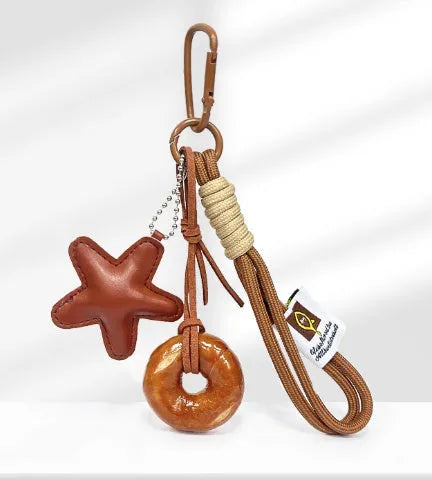 Handmade soda bread handbag charm pendant with cartoon croissant design and brown strap