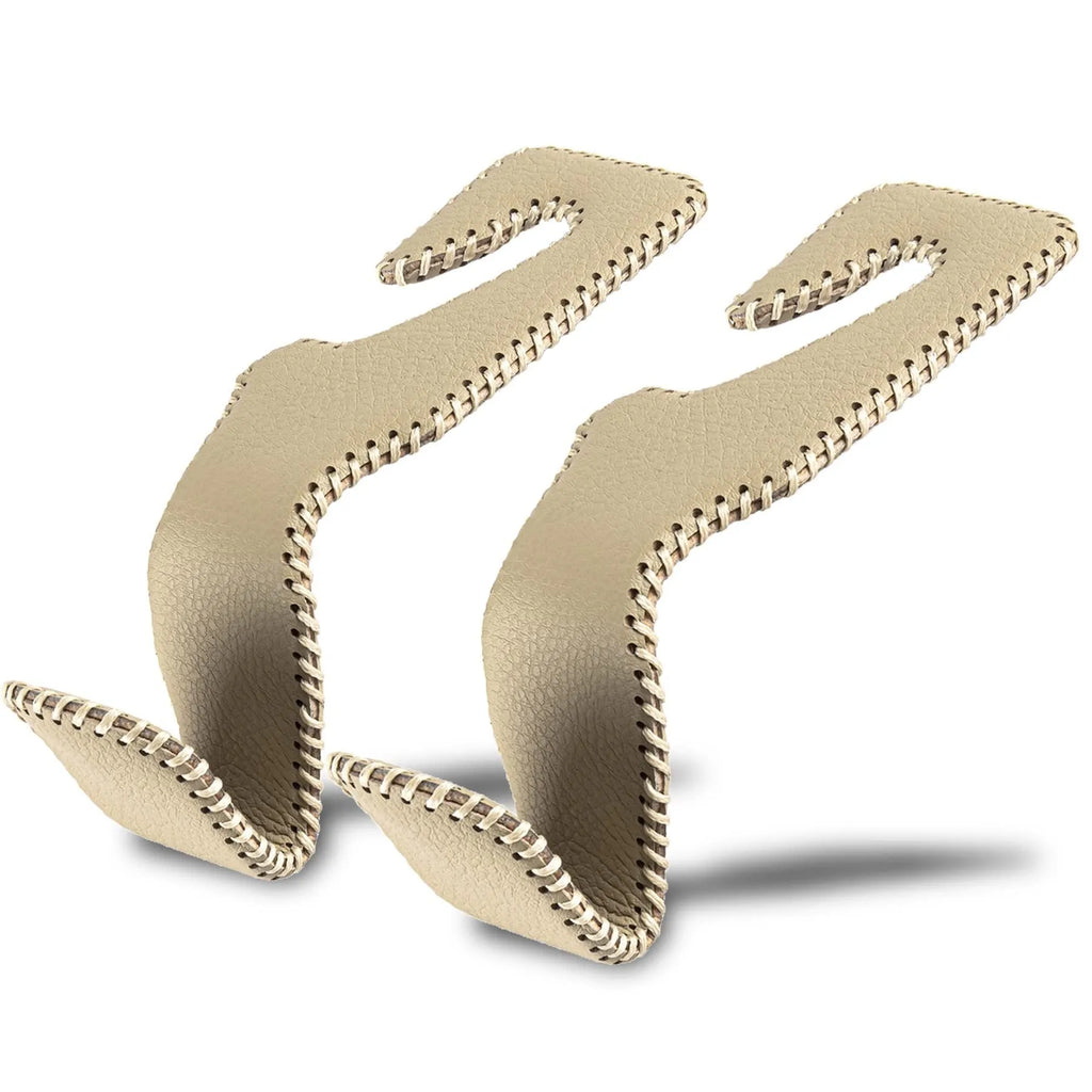 Stainless steel car seat back hook with gold finish clipped onto a car headrest, holding a shopping bag.
