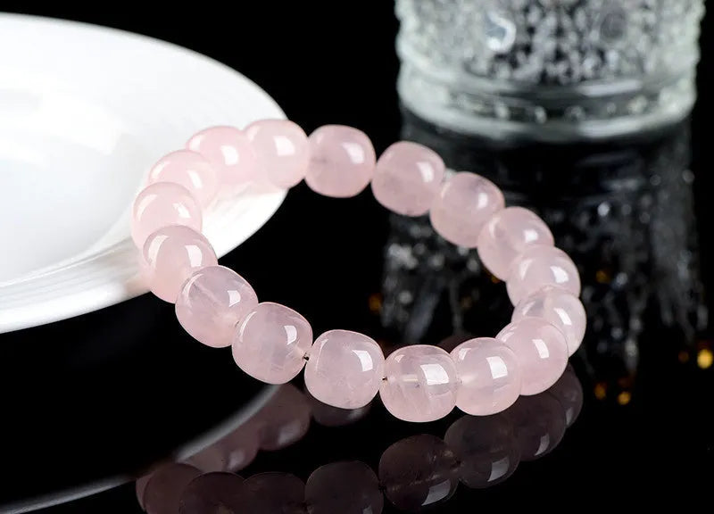 Pink crystal barrel bead bracelet with geometric design on a bamboo string.