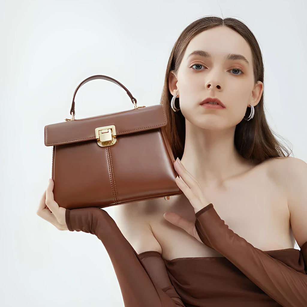 Dark brown genuine leather women's shoulder bag with a clasp, showing its horizontal square shape and shoulder strap.