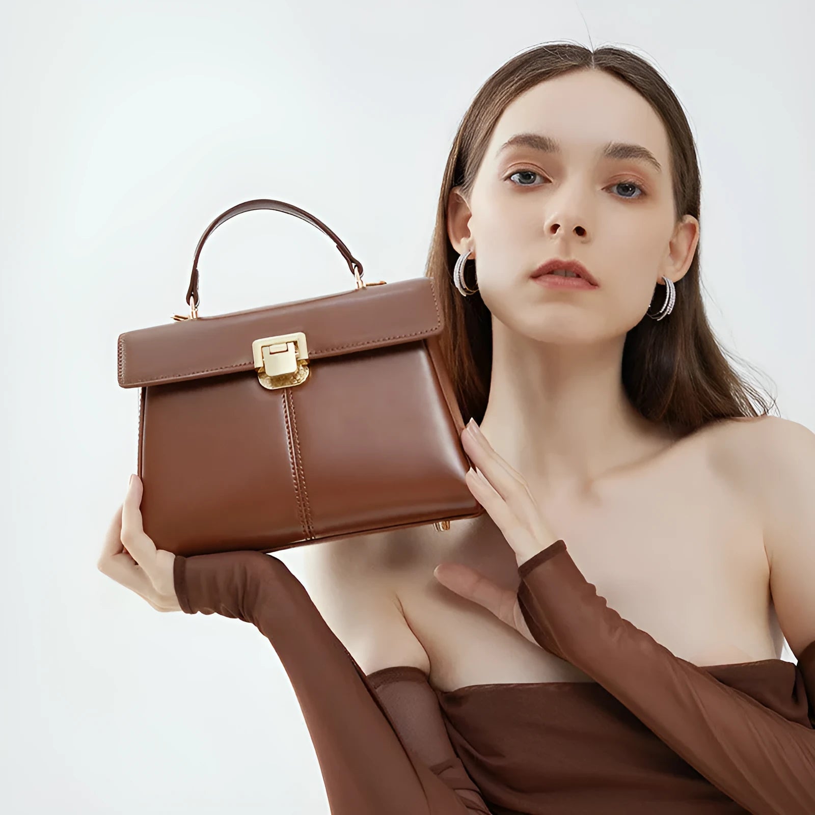 Dark brown genuine leather women's shoulder bag with a clasp, showing its horizontal square shape and shoulder strap.