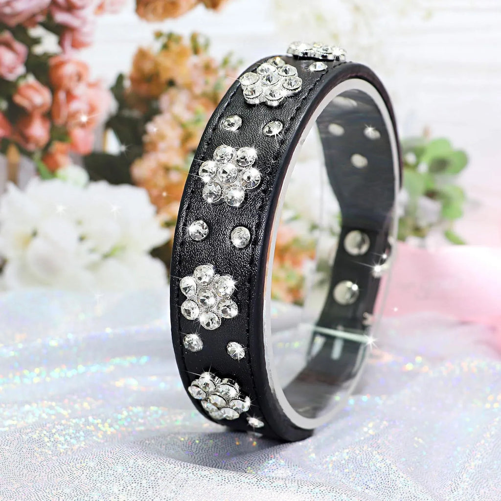 Black PU leather dog collar with sparkling rhinestone flower studs and a metal D-ring.