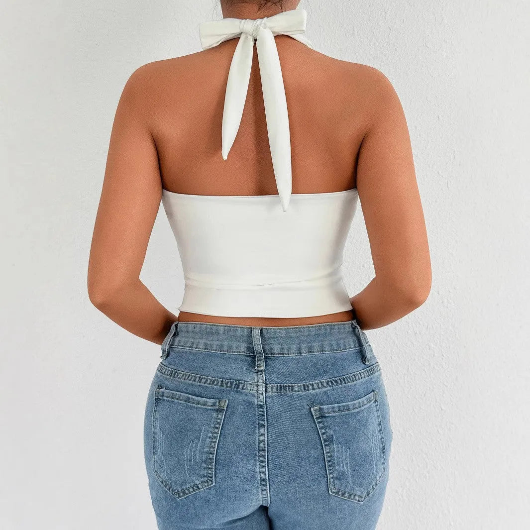 White sleeveless V-neck crop top with lace-up backless detail on woman against neutral background