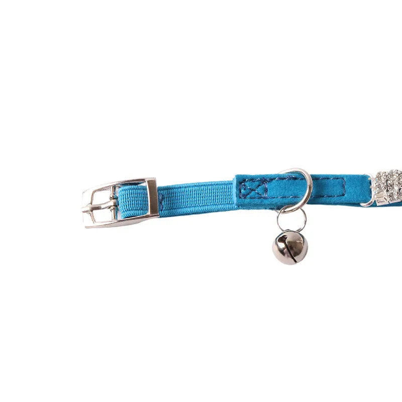 Soft pink flocked cat collar with an elastic section and plastic buckle on a grey background.