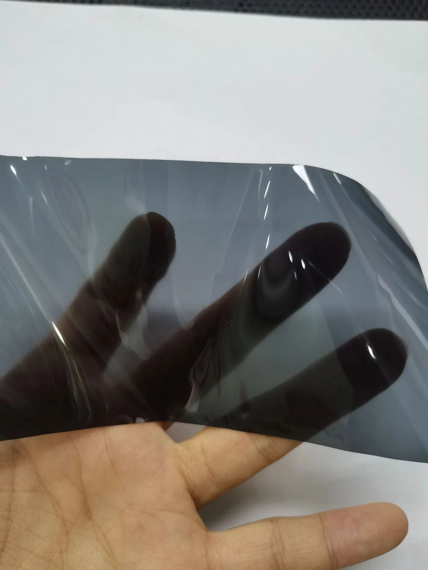 A roll of 30cm wide dark grey car lamp protective film for headlight and taillight protection.