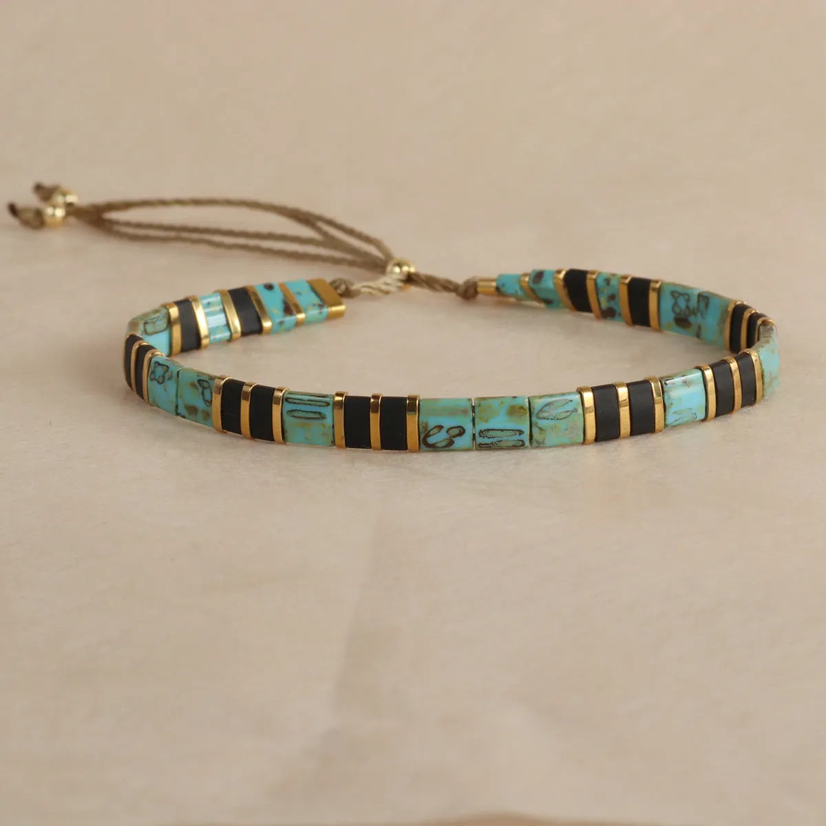 Geometric pull bead bracelet with glass and coloured glaze beads in round design