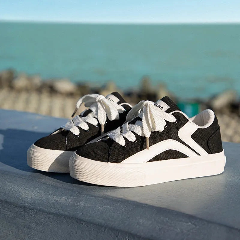 Women's blue and white low-top board shoes with vulcanised rubber soles and lace-up front.