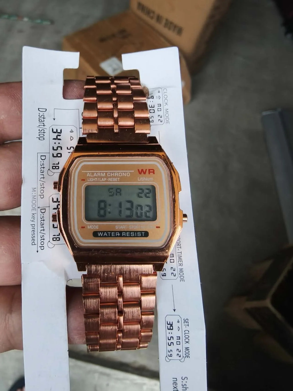 Rose gold analogue watch with round stainless steel case, luminous hands, and date display on a white background