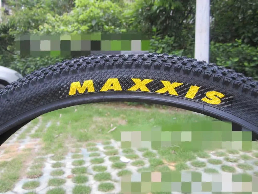 A mountain bike tyre showing tread pattern, with options for 26, 27.5, and 29-inch wheel sizes.