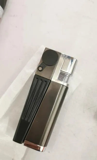 Silver foldable metal pipe lighter in open position showing flame mechanism and storage compartment.