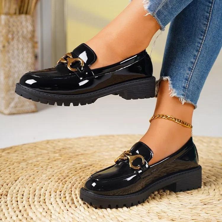 Women's black chunky heel pumps with round toe, thick rubber soles, and metal decorative accents