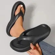Women's black flip-flop slippers with a thick textured EVA sole and wide strap.