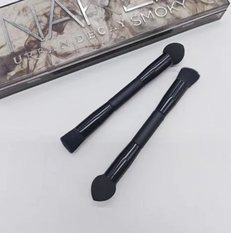 Black double-headed concealer brush with sponge end and tapered brush end on wooden handle