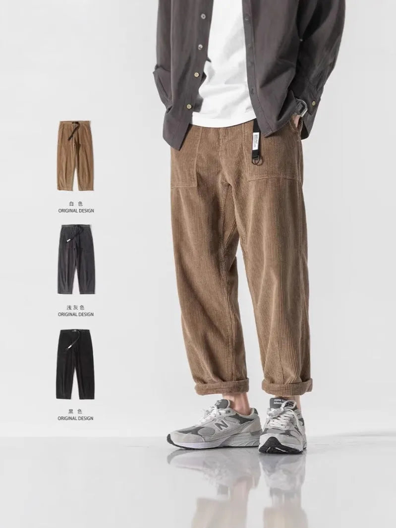Man wearing loose straight tapered trousers in dark grey, showcasing the straight leg and relaxed fit.