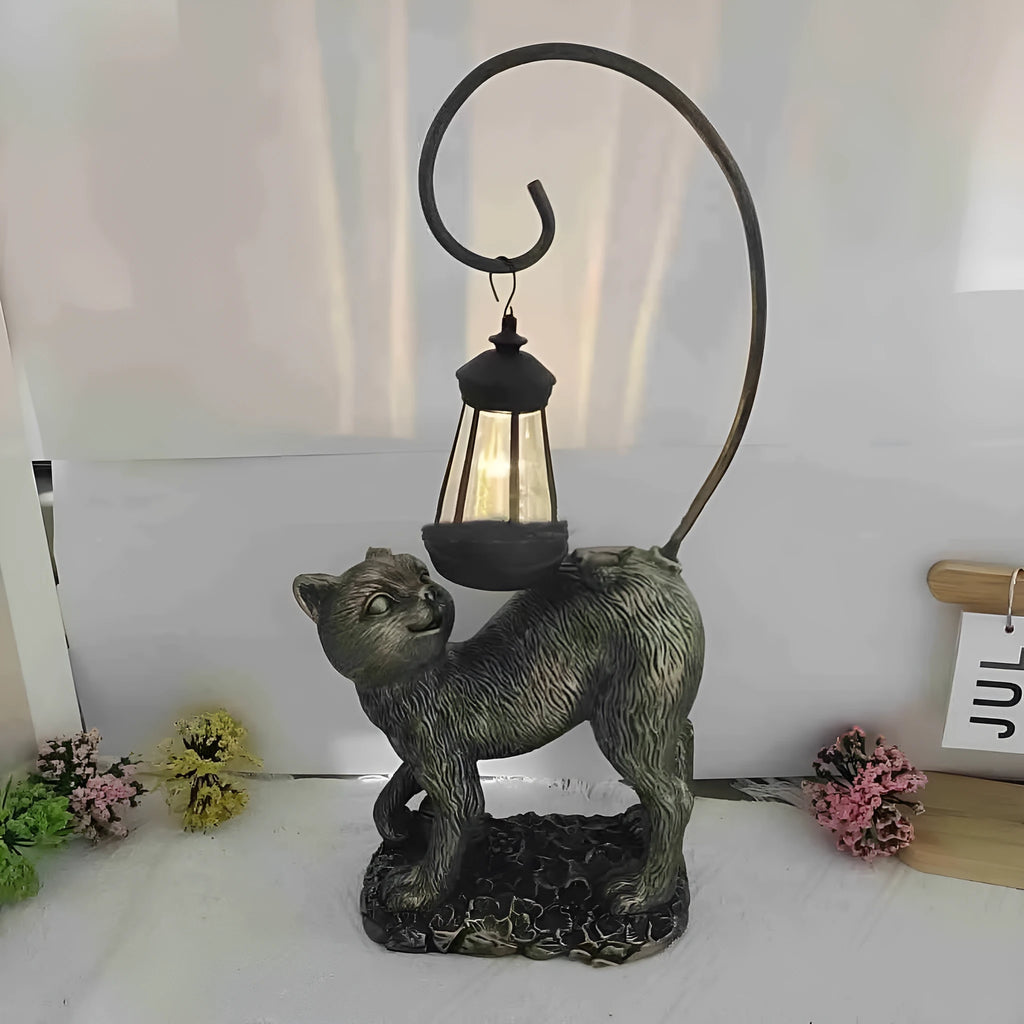 Bronze resin cat solar garden lamp on a garden path, outdoor decoration