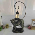 Bronze resin cat solar garden lamp on a garden path, outdoor decoration