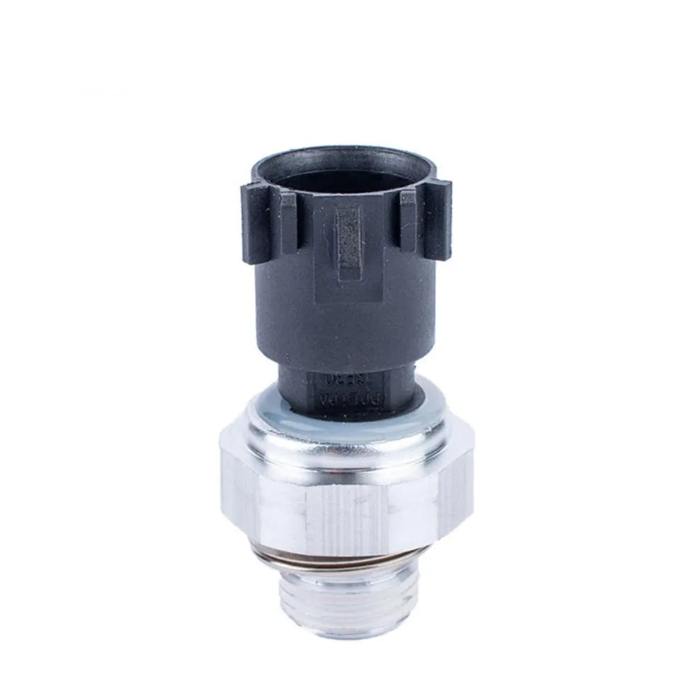 Silver automobile fuel pressure sensor on a white background.