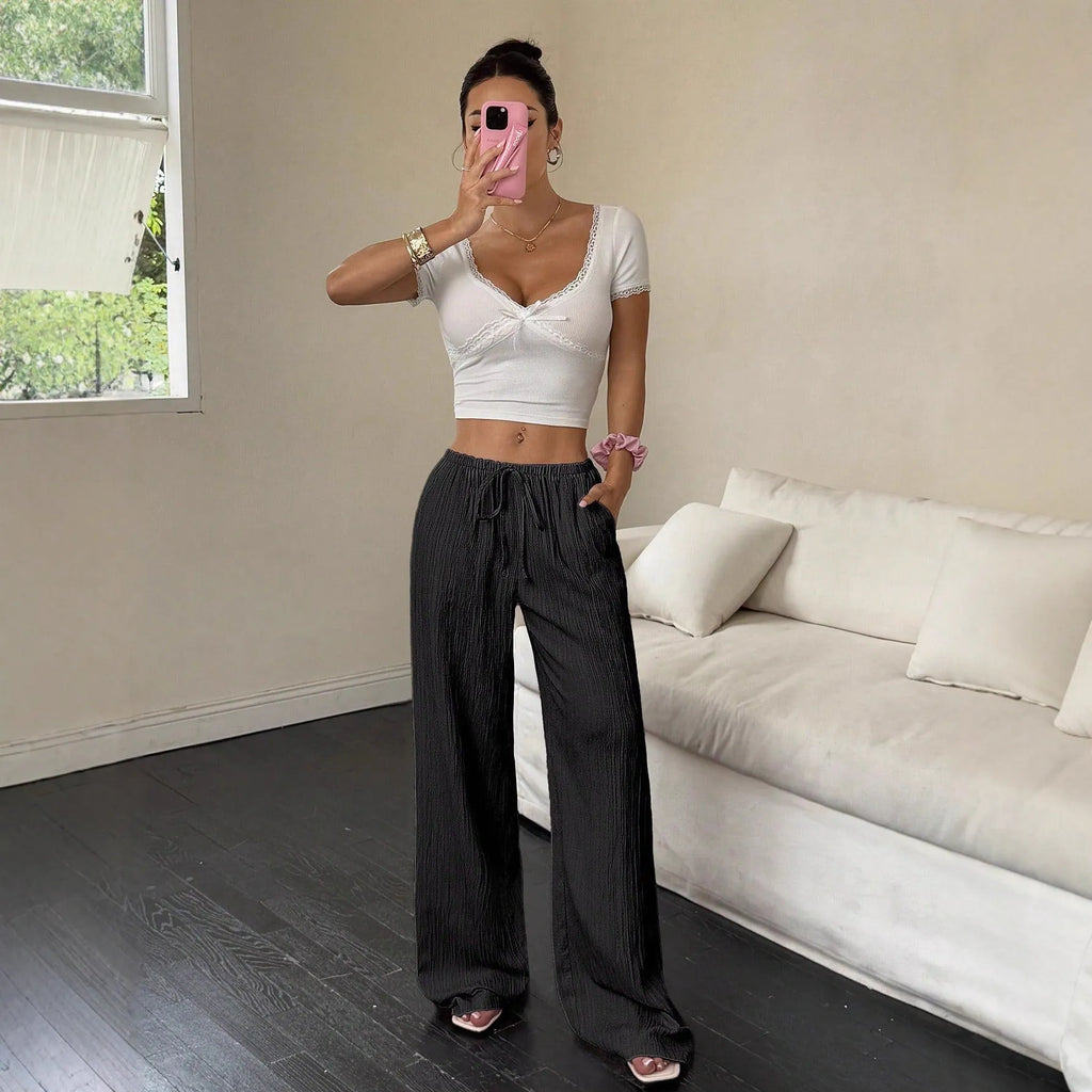 Women's black wide-leg trousers with a front lace-up detail on the mid-rise waistband.