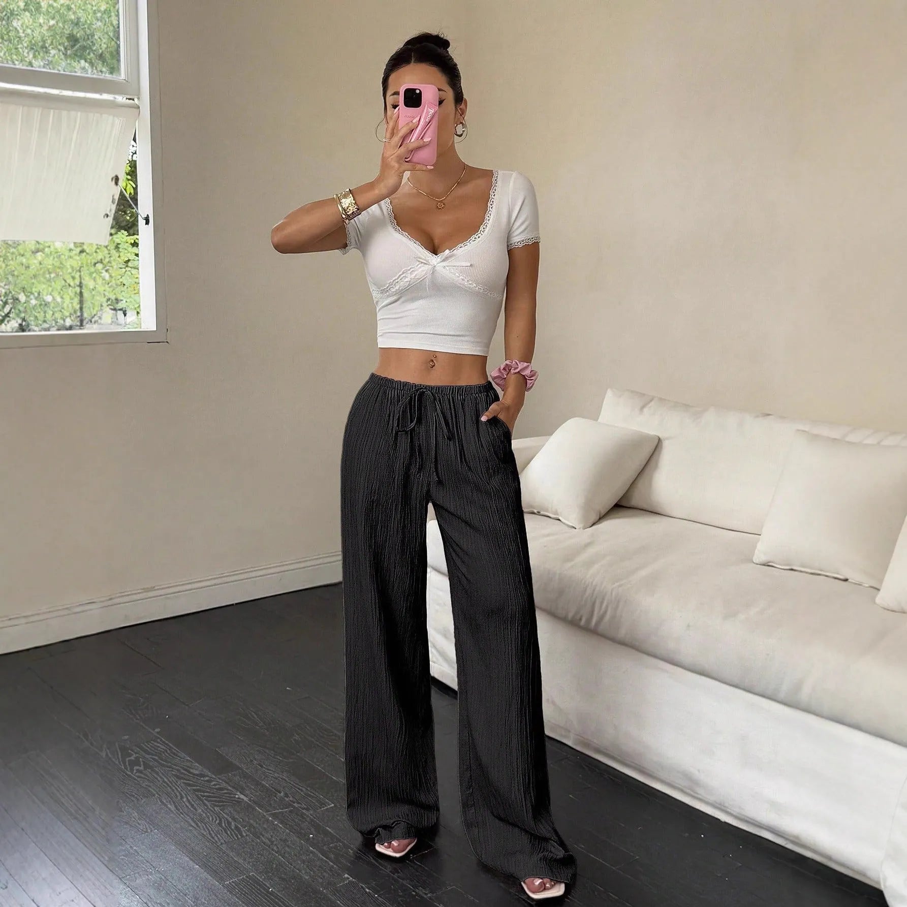 Women's black wide-leg trousers with a front lace-up detail on the mid-rise waistband.