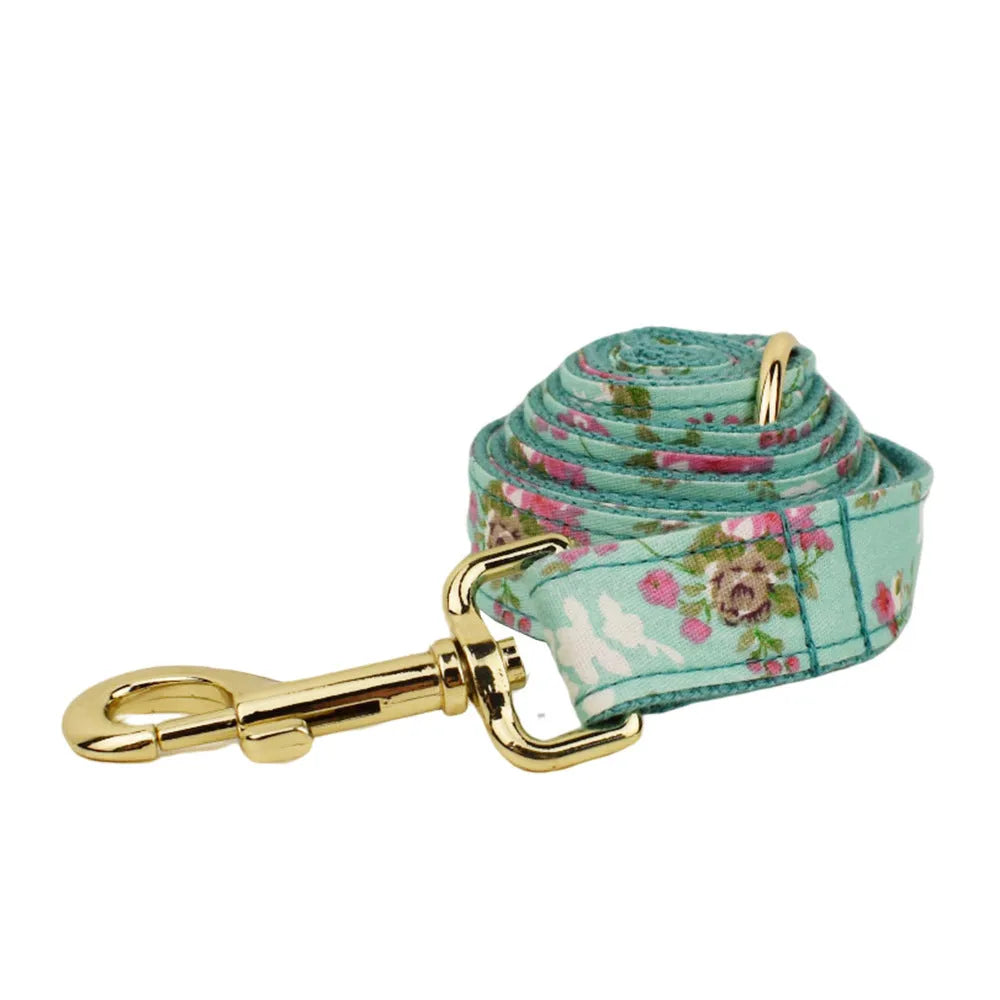 Rose-coloured fabric dog collar set with green background, includes leash, detachable bow, and vest for dogs.