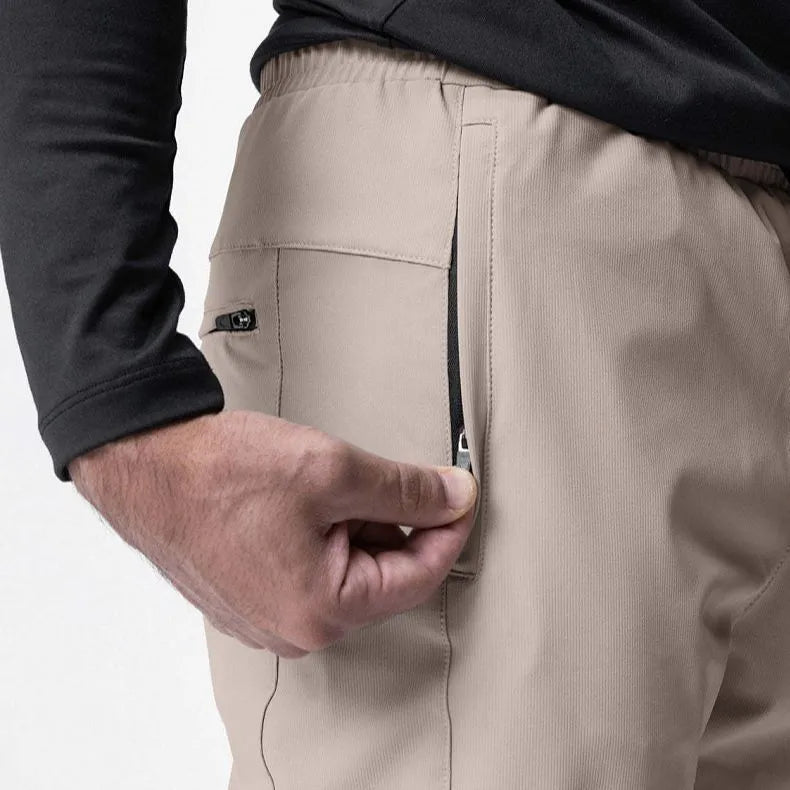 Man wearing dark grey loose-fit fitness trousers with tied ankle cuffs, suitable for gym training.