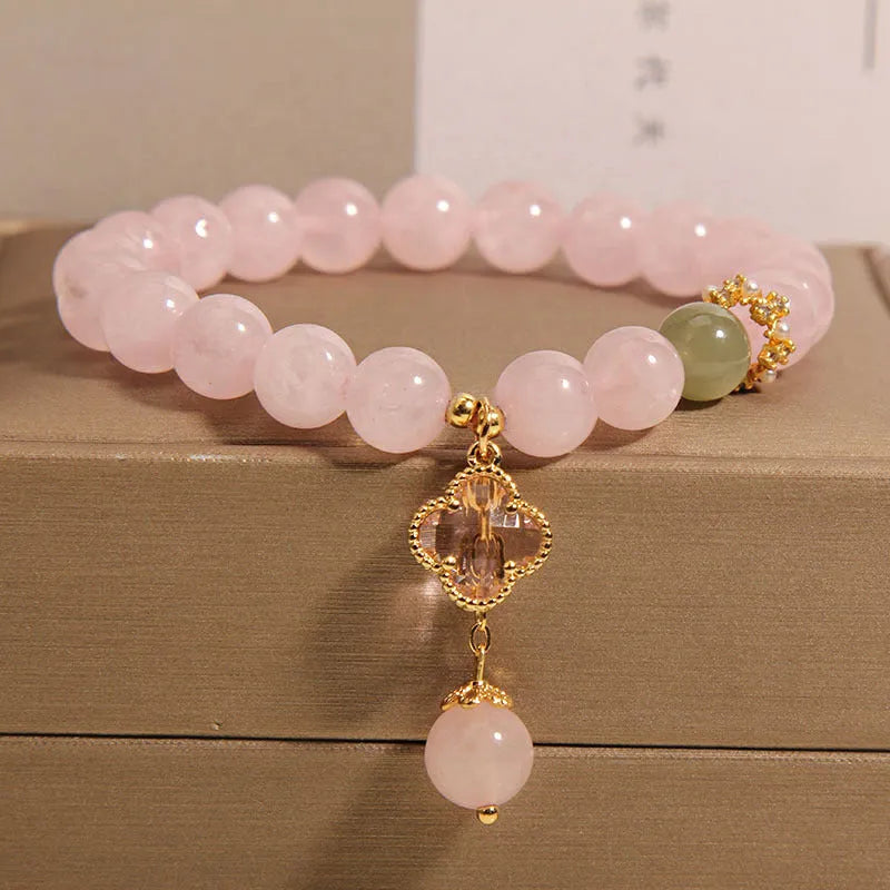 Pink crystal bracelet for women with a four-leaf clover pendant, alloy inlay, and rhinestones.