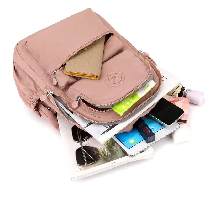 Women's waterproof nylon travel backpack with multi-compartments in rose red colour showing organisational features
