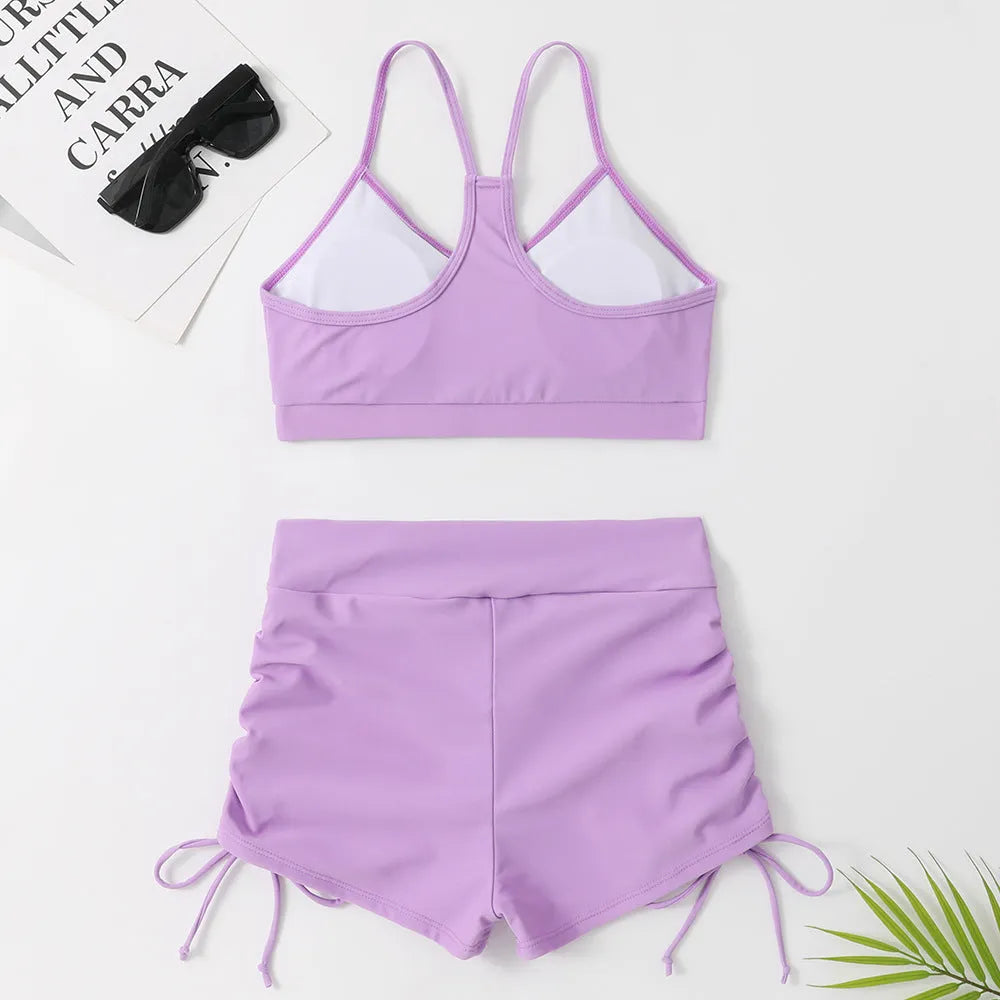 A purple high-waist split swimsuit for women, showing the bikini briefs style and sleeveless design.