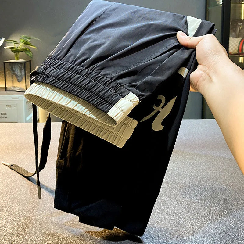 Men's black ultra-thin ice silk ankle banded casual trousers showing cropped design with elastic cuffs