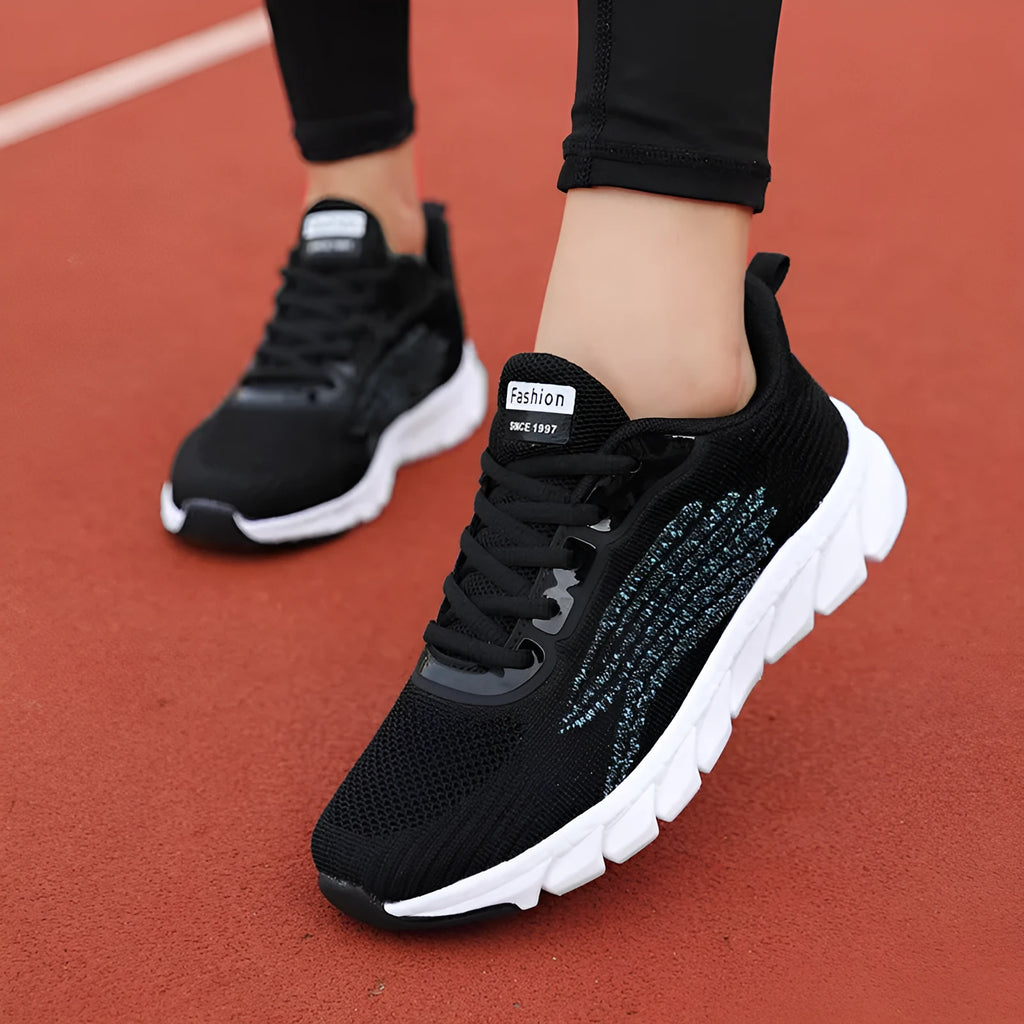 Low-top black and white running sneaker with cross strap and round toe on MD sole.