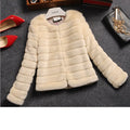 Women's short length faux fur top in beige on a model, showing regular sleeves and street fashion style.
