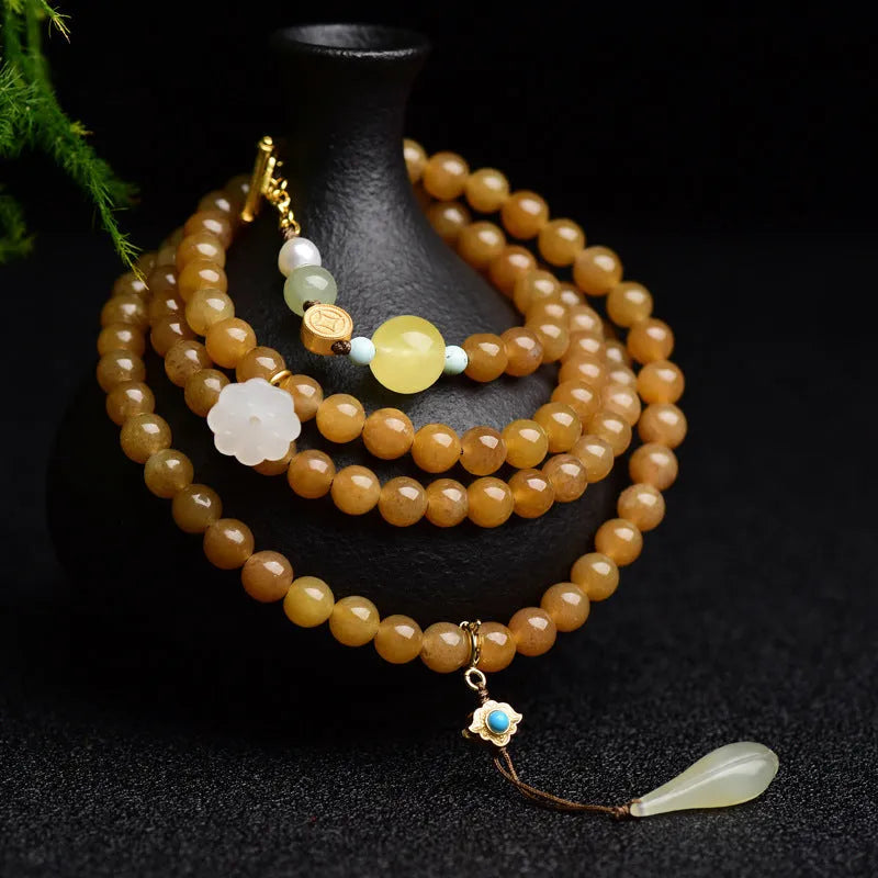 Green jade bracelet with round 6mm beads, beeswax and pine leaf charms on natural background