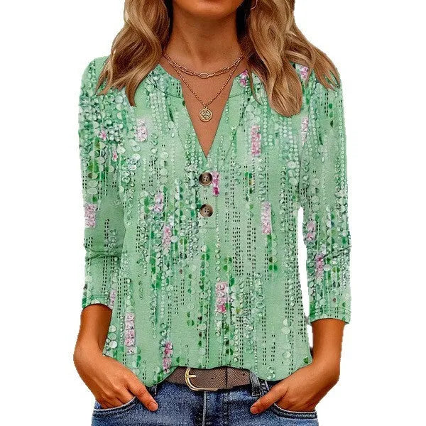 Woman wearing a loose grey V-neck top with a white 3D-effect geometric pattern print.