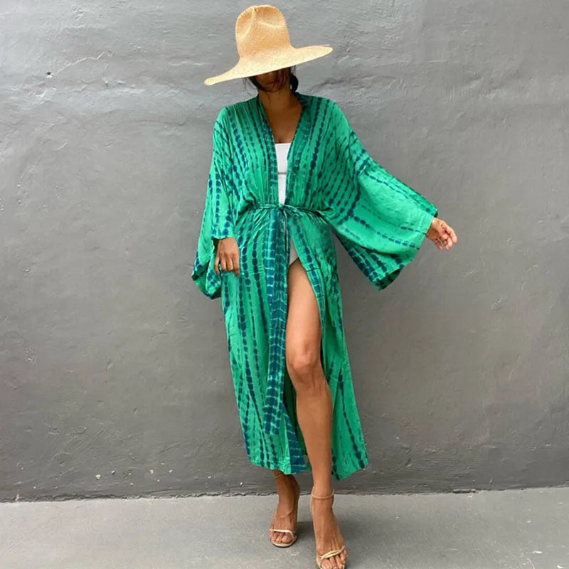 A woman wearing a loose, printed cotton cover-up blouse over swimwear at the beach.
