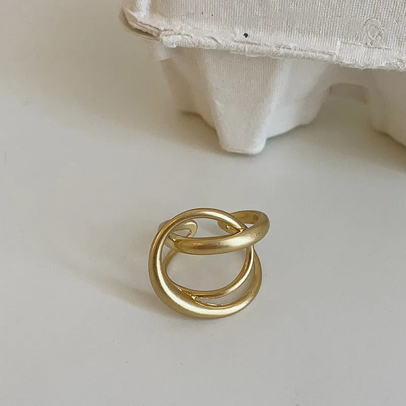 Geometric interlaced matte metal open ring for women in gold or silver colour.