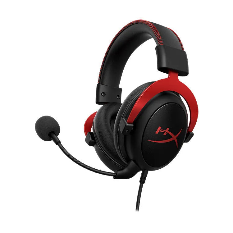 Black and red wired gaming headset with detachable microphone and separate USB sound card remote control on a desk.