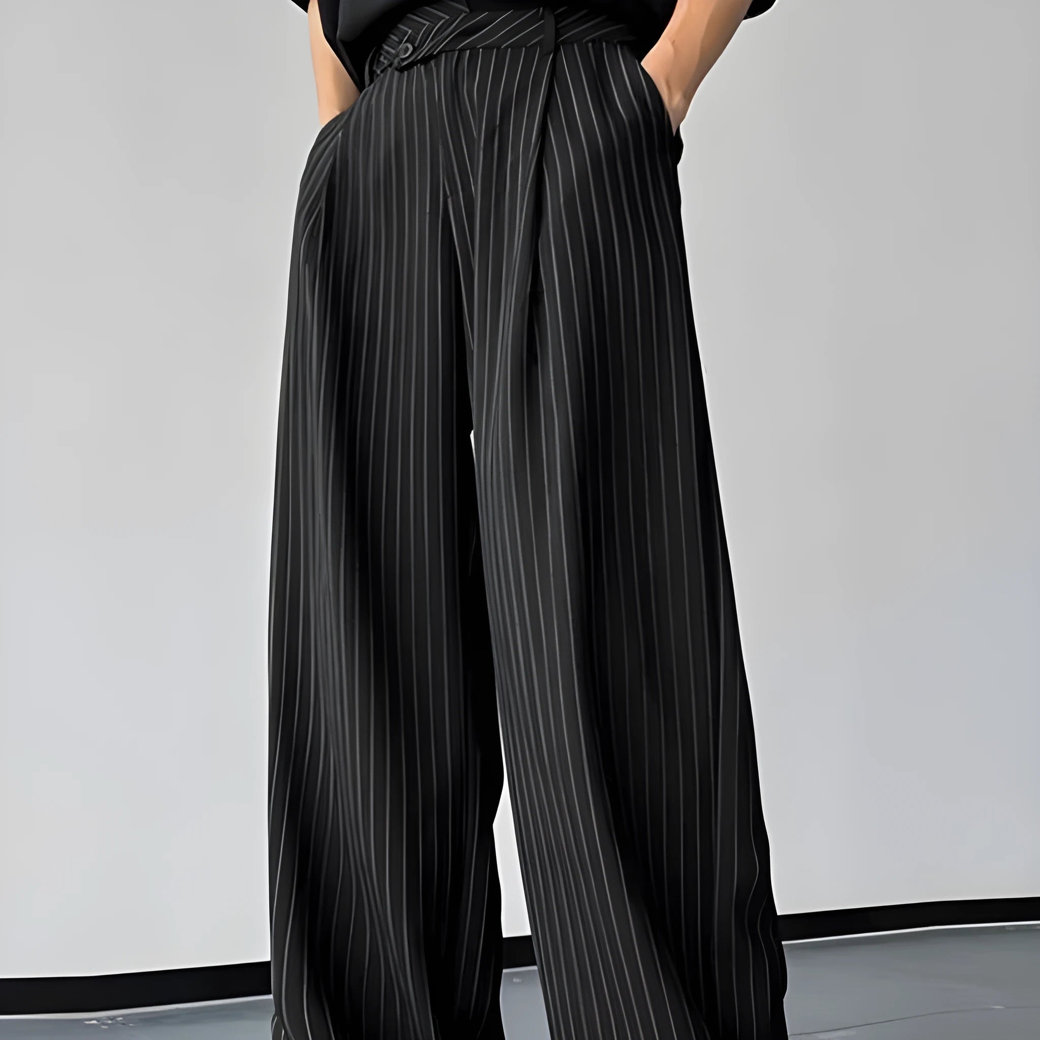 Black men's casual trousers with vertical stripes and front pleats on a hanger.