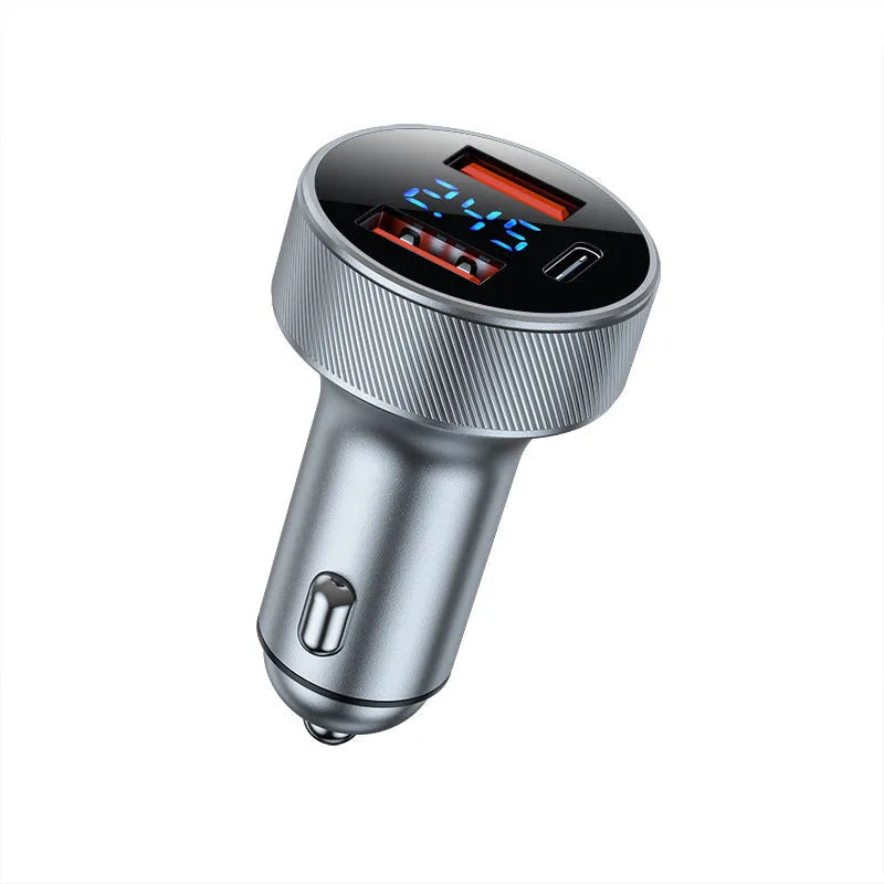 Black aluminium alloy car charger with digital display plugged into a vehicle cigarette lighter.