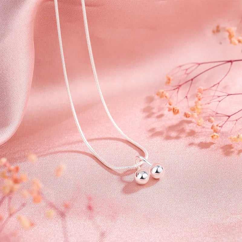 S925 sterling silver adjustable cherry pendant necklace with a snake bones chain on a white background.