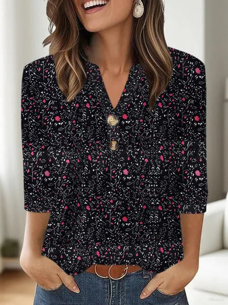 Woman wearing a loose grey V-neck top with a white 3D-effect geometric pattern print.