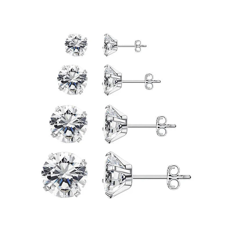Simple geometric stud earrings with zircon stone in gold or steel colour on grey background.