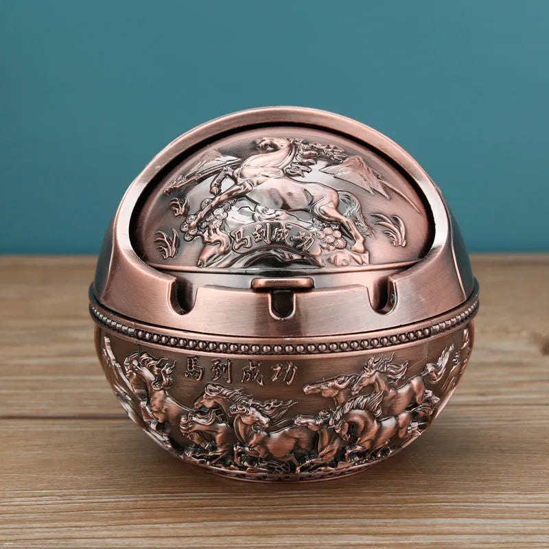 Alloy decorative ashtray in bronze with ornate peacock motif and cigarette extinguishing slot.