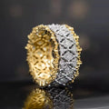 Geometric two-tone copper ring with a round zircon stone, shown on a hand.