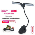 Black clip-on music stand lamp with 28 LEDs, shown with USB cable and AA batteries.