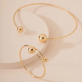 Gold silver ball dislocation thin open-end bangle bracelet with matching necklace ornament on white background