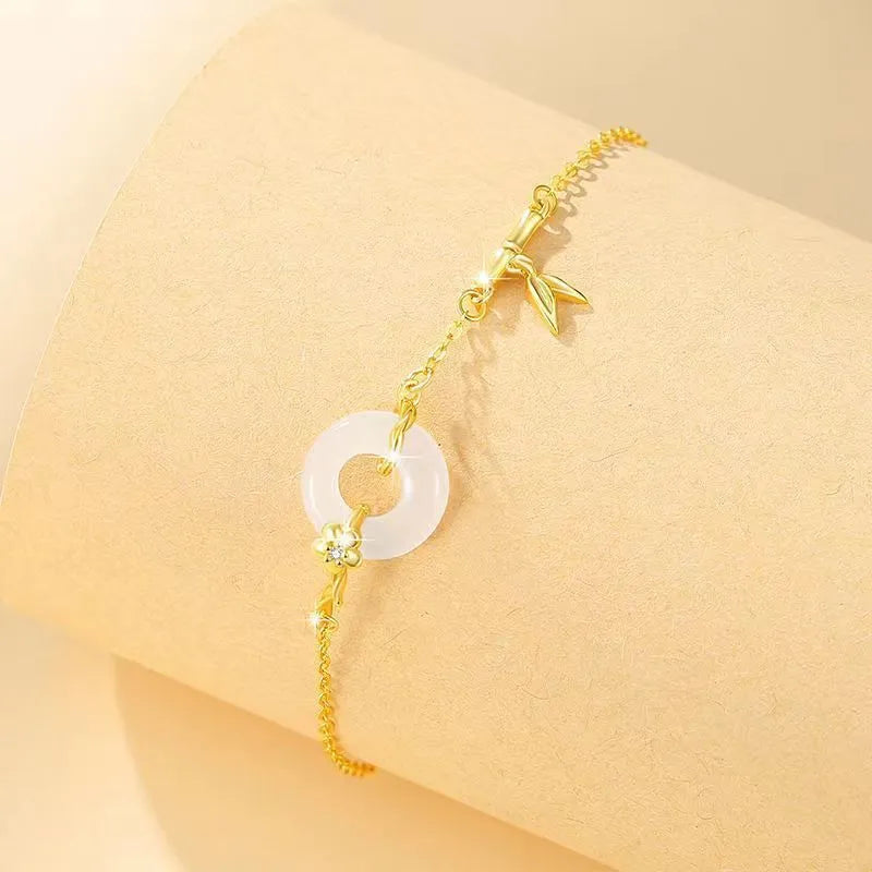 Silver gold electroplated women's bracelet with a white chalcedony stone and prominent peace buckle clasp on a 22 cm band.